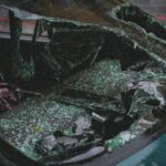 Detailed view of shattered car windshield after accident, emphasizing damage and broken glass.