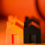Vibrant and contrasting orange and black miniature house models symbolizing real estate concepts.